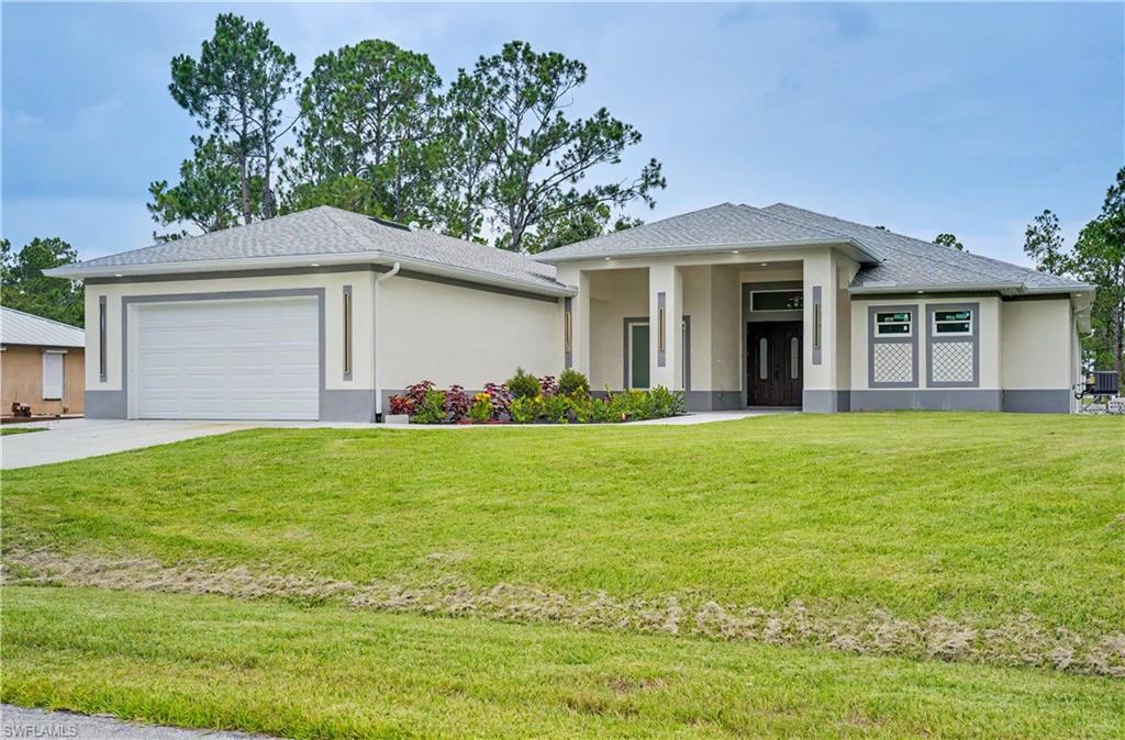 Contemporary stucco exterior with a gray trim, featuring a dark wood double-door entry and an attached two-car garage