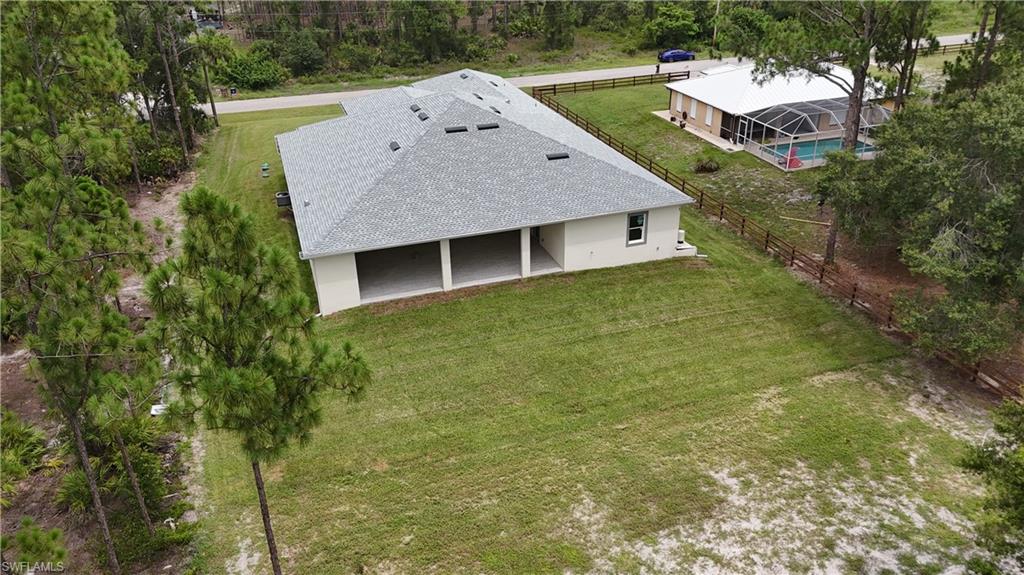 Expansive grass lawn with mature trees, offering a significant outdoor area