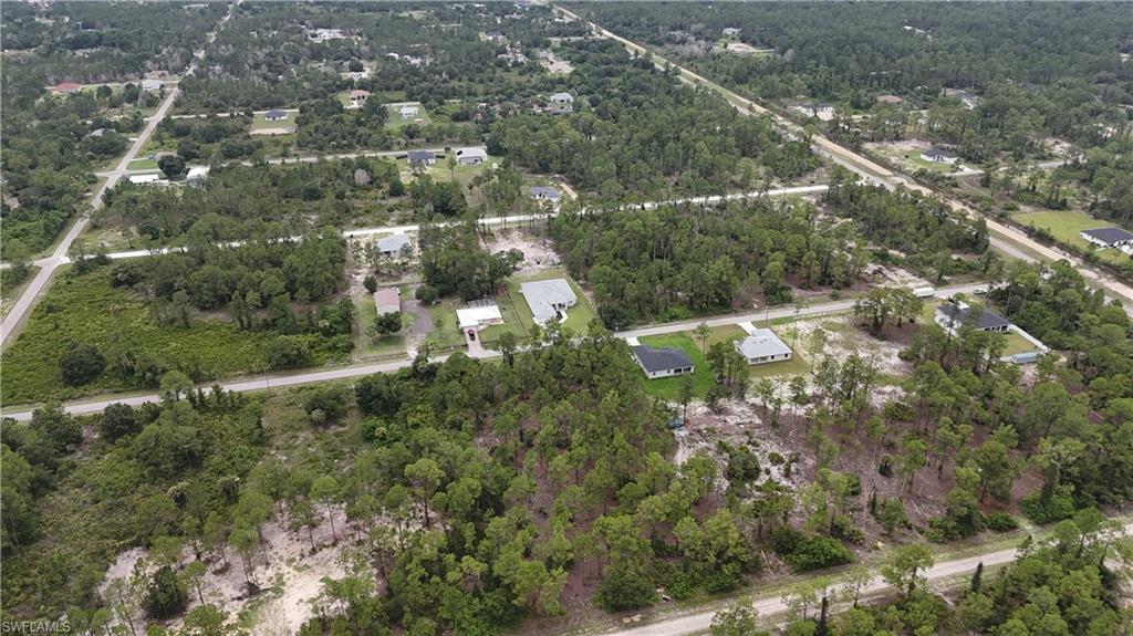 Aerial view showcasing multiple residential properties interspersed with undeveloped land