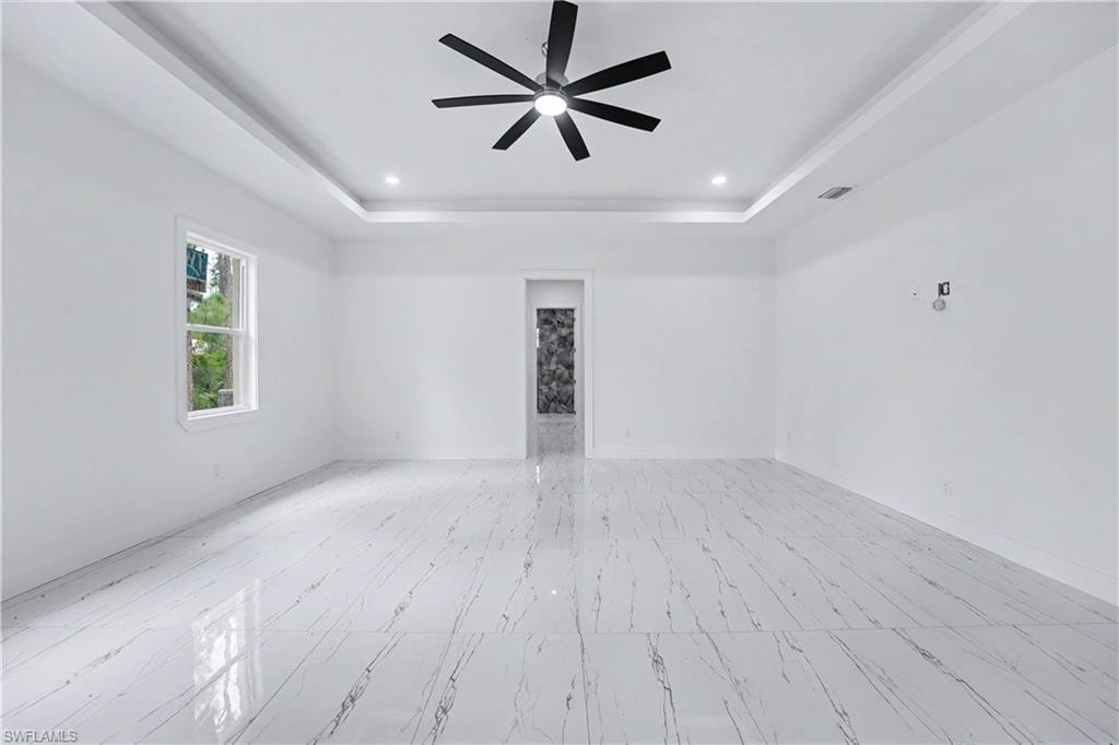 Spacious room featuring white walls and large-format porcelain tile flooring with a marble-effect pattern