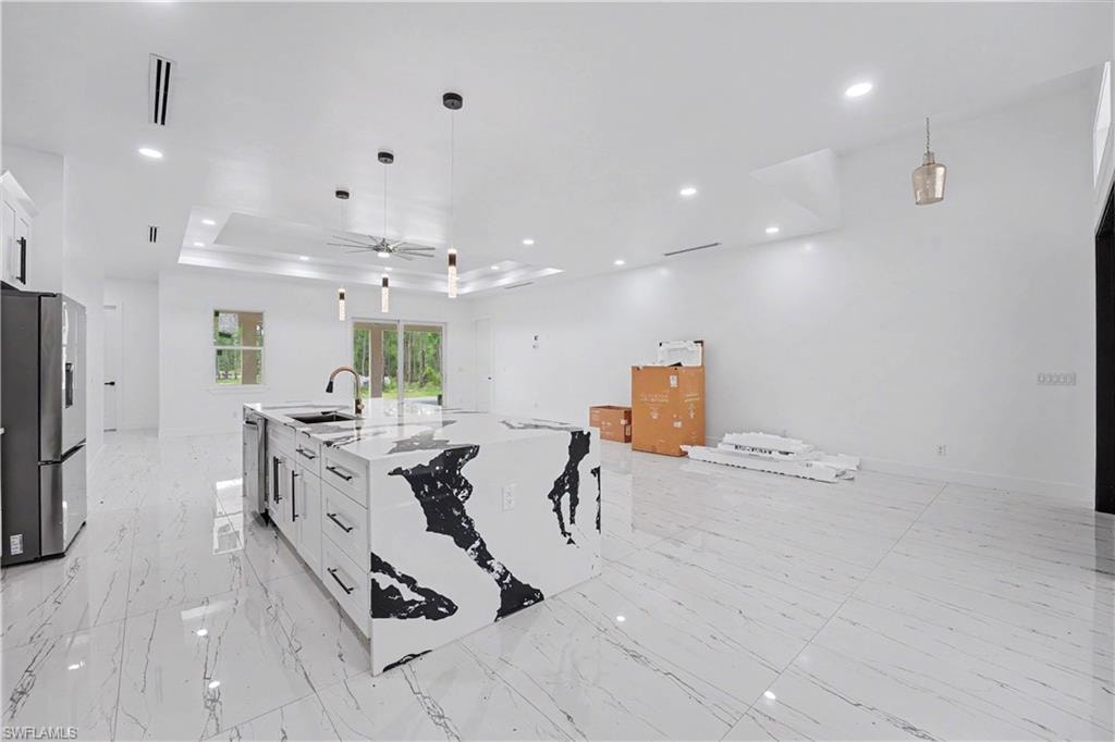 Open-concept living space with large format tile flooring and a prominent waterfall island featuring a striking black and white pattern