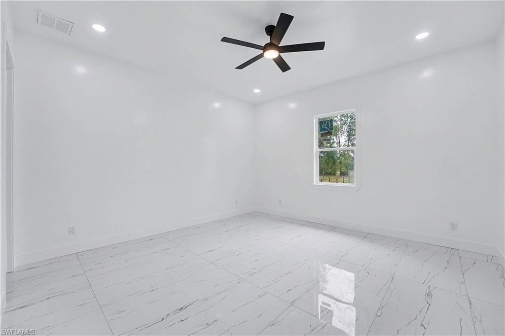 Spacious room featuring large format tile flooring, a contemporary ceiling fan with integrated lighting, recessed lighting, and a window with white trim