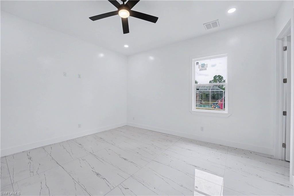 Bright interior space featuring white walls and large format tile flooring