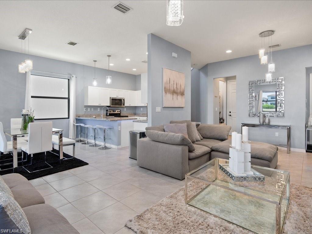 Open-concept living space featuring light-toned tile flooring throughout