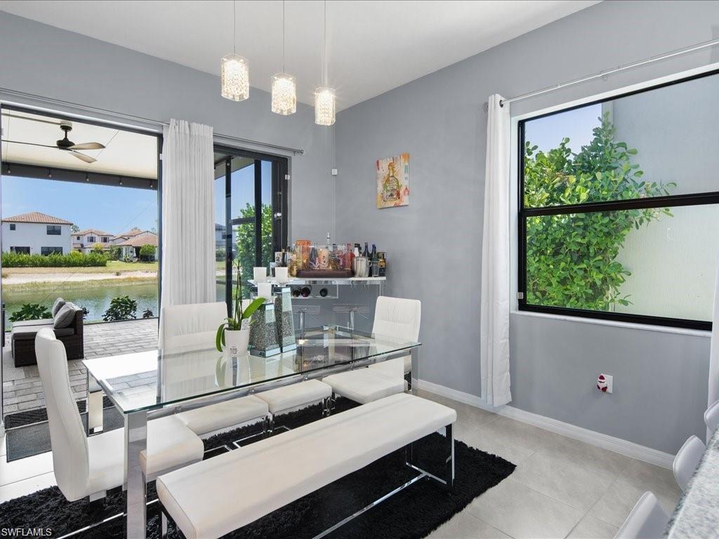 Spacious room featuring light gray walls, a large window, and sliding glass doors opening to an outdoor patio area
