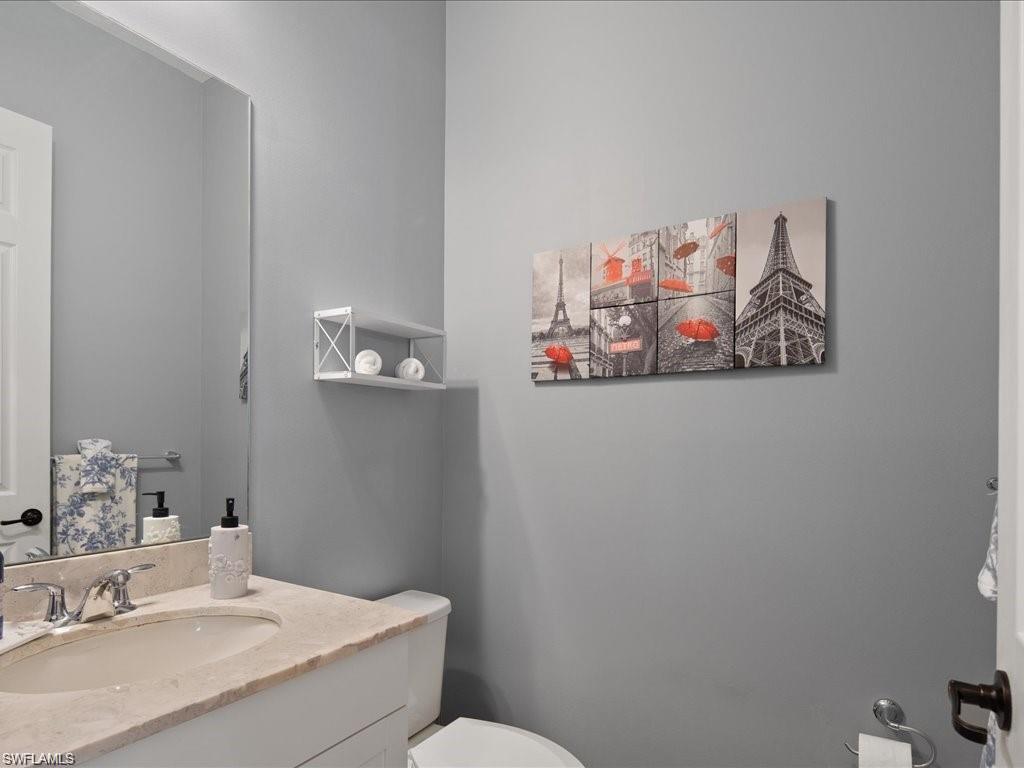 Bathroom vanity with a light-colored countertop, undermount sink, and chrome faucet