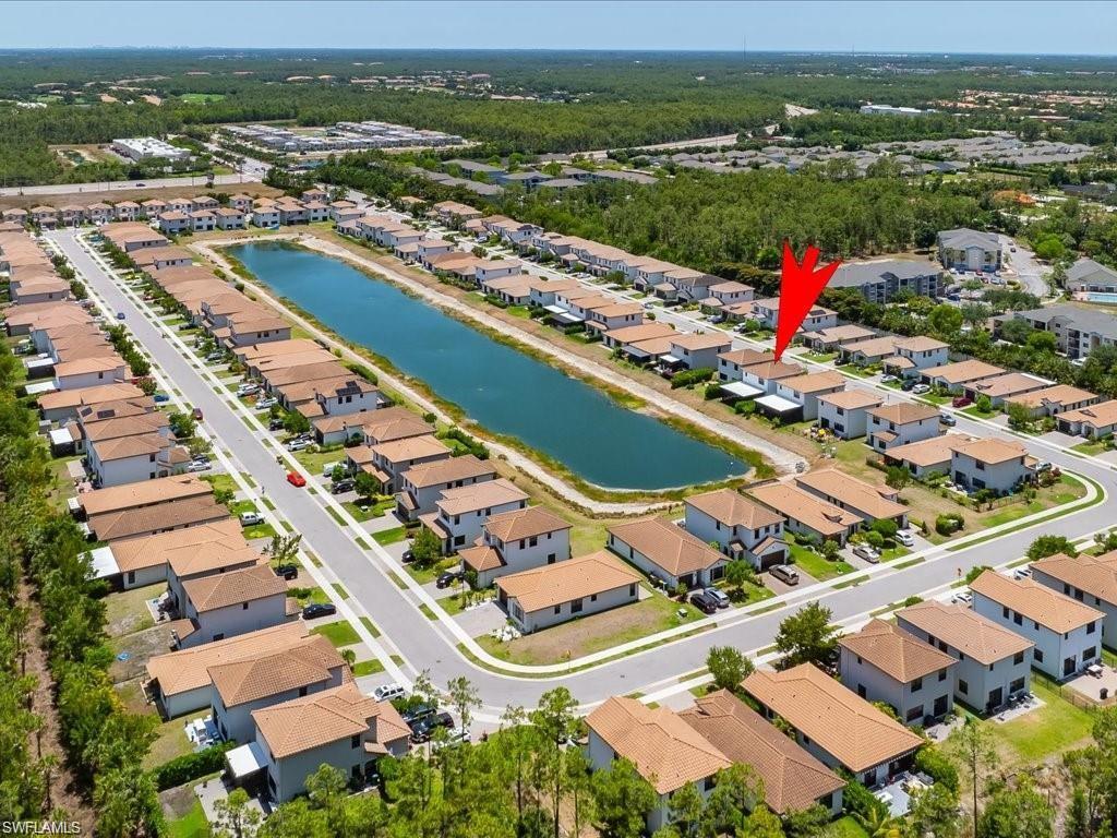Aerial view of a residential community featuring a prominent central water body