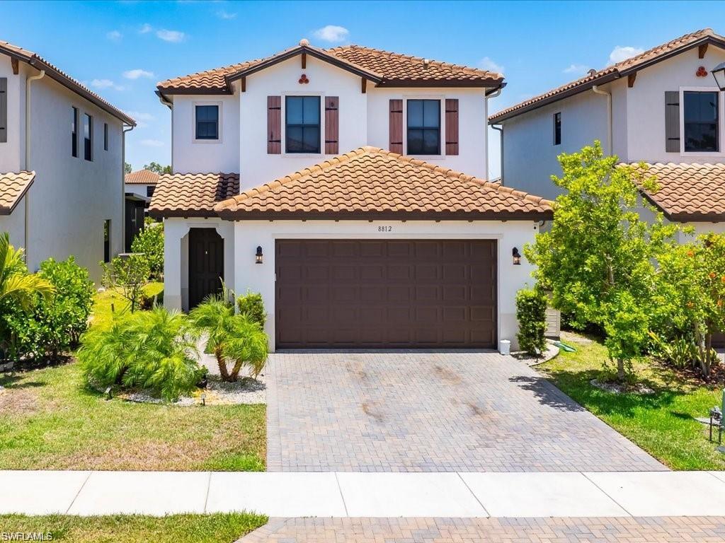 Contemporary stucco exterior featuring a terracotta tile roof