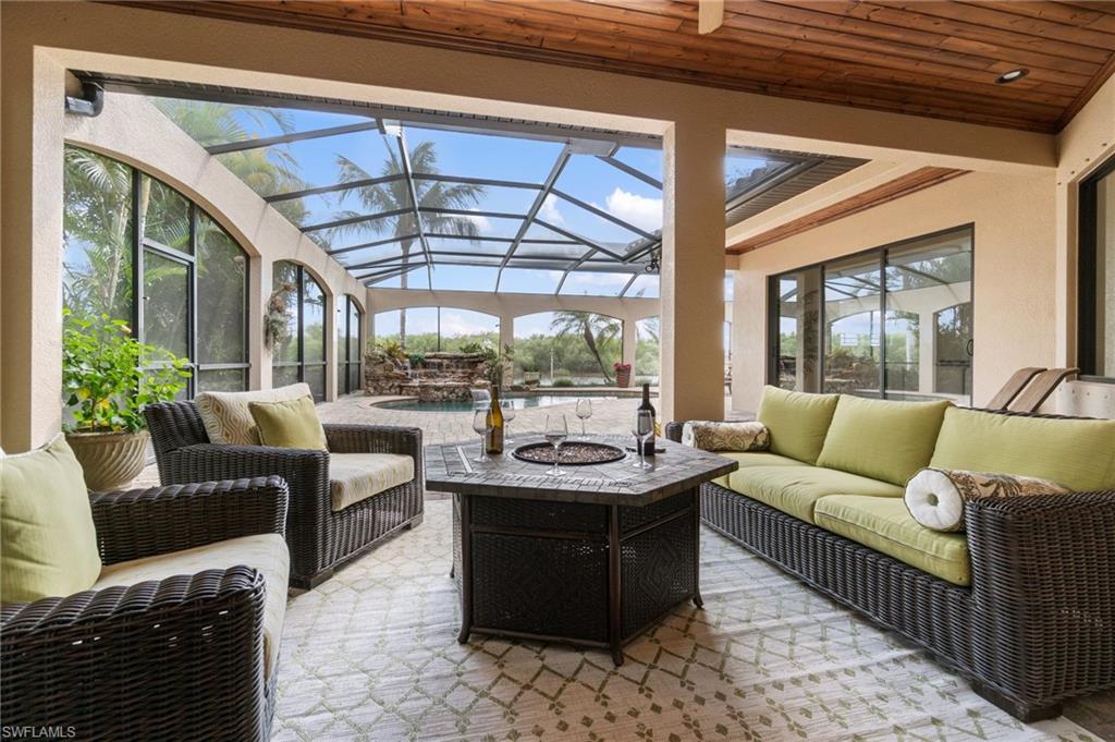 Expansive covered patio featuring a wood-panel ceiling and an enclosed pool area
