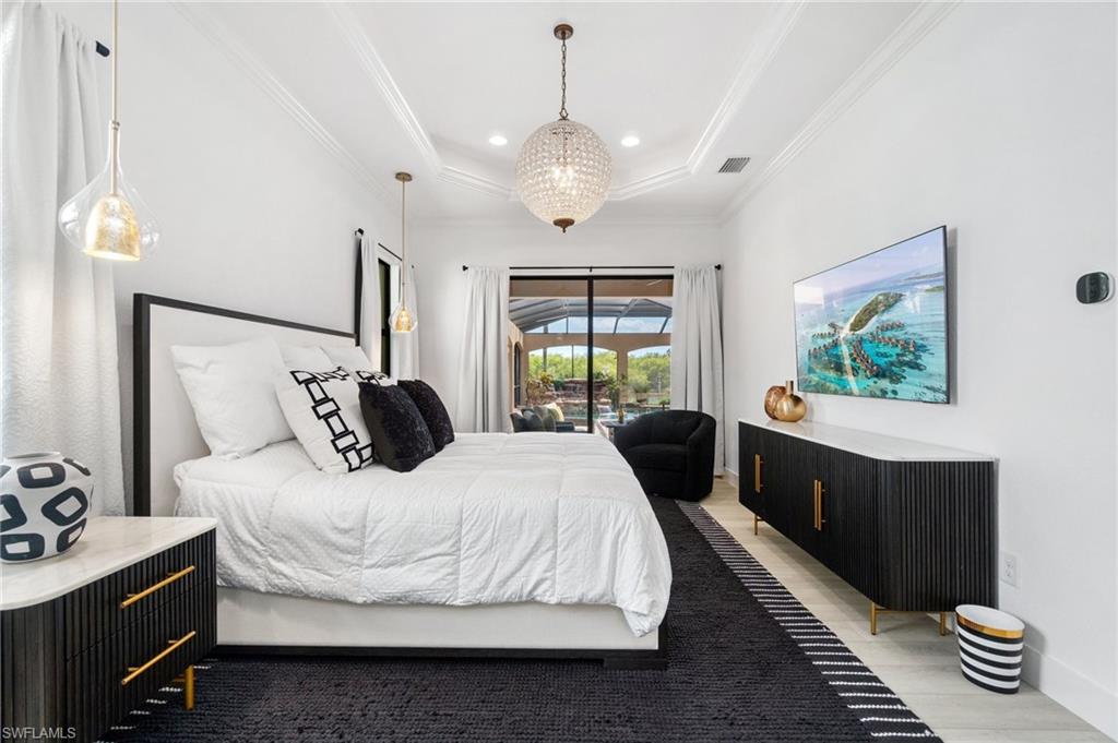 Interior space with a tray ceiling and a large glass door opening to an outdoor area
