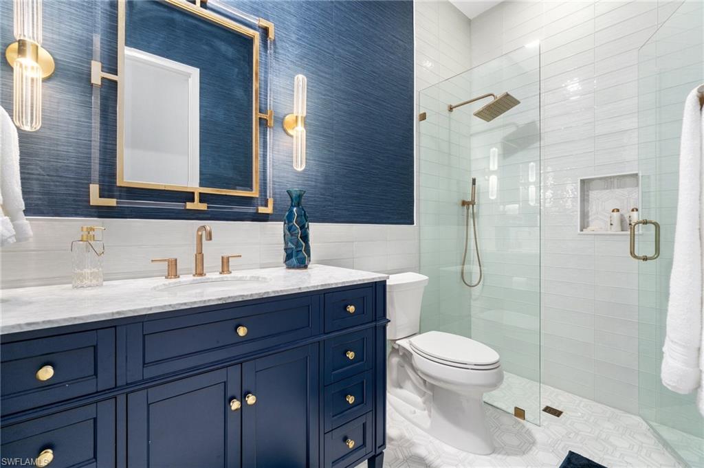 Custom vanity with a white countertop and gold-finish fixtures
