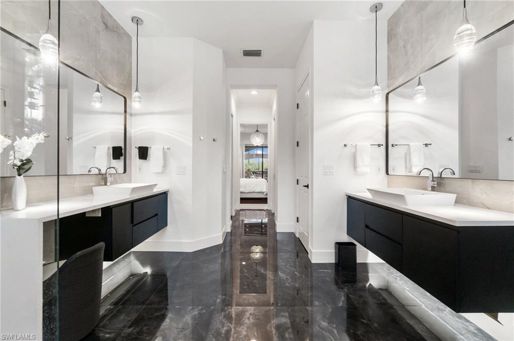 Dual floating vanities with white vessel sinks, quartz countertops, and contemporary pendant lighting