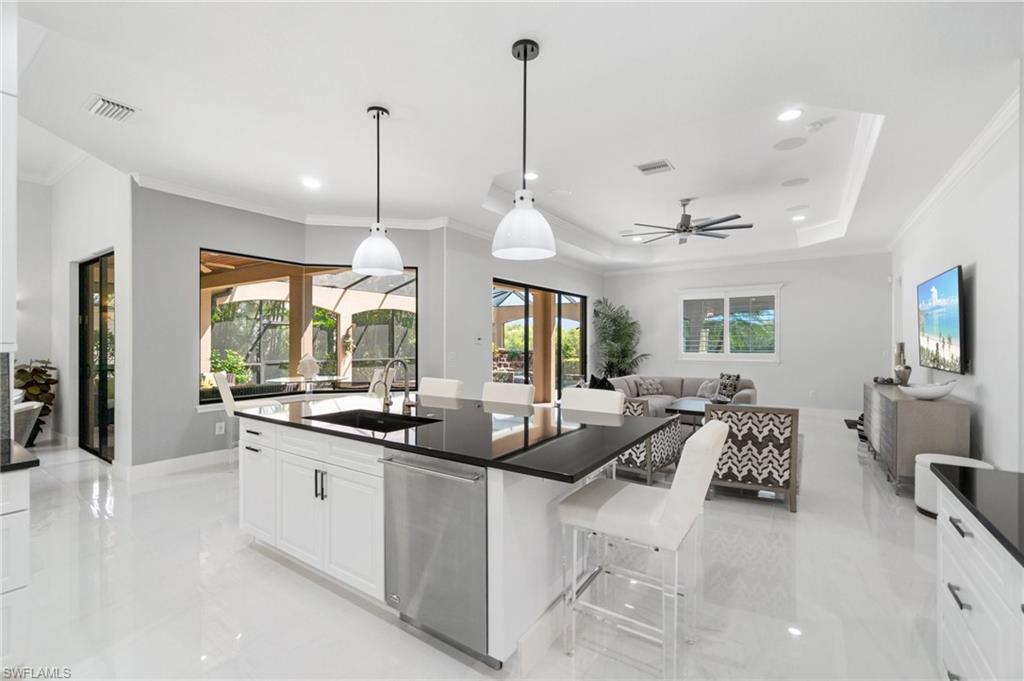 Contemporary kitchen island with a black countertop, integrated sink, and stainless steel dishwasher
