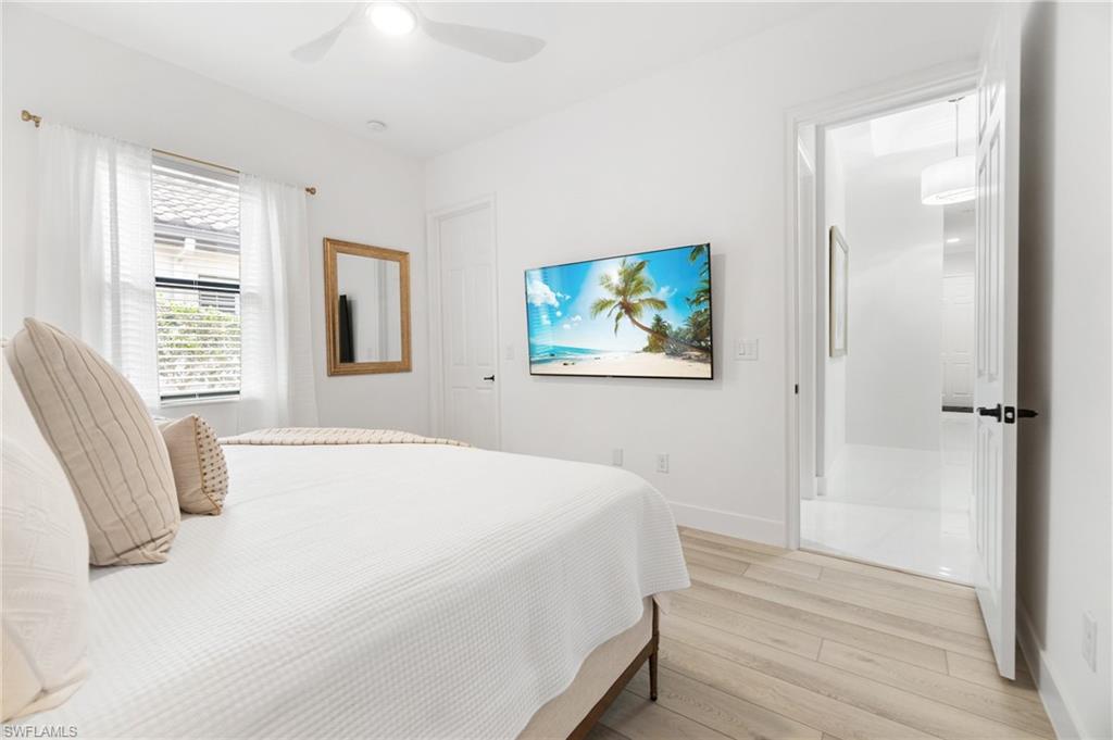 Bright room featuring light wood-finish flooring and a ceiling fan