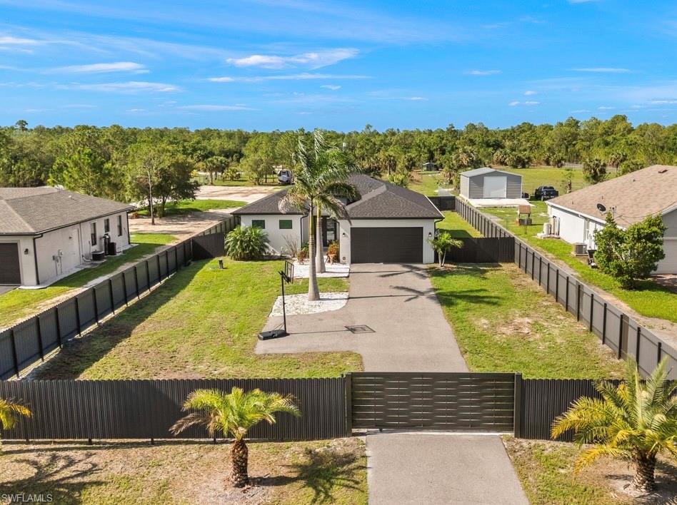 Modern single-story residence featuring a dark shingle roof, attached two-car garage, and a gated driveway