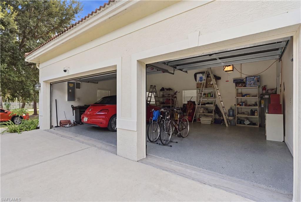 Multi-car garage featuring a concrete driveway and an epoxy-coated floor