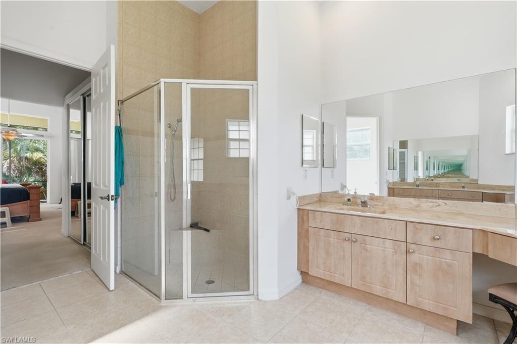 Bathroom featuring a glass-enclosed shower with tiled walls and a built-in seat