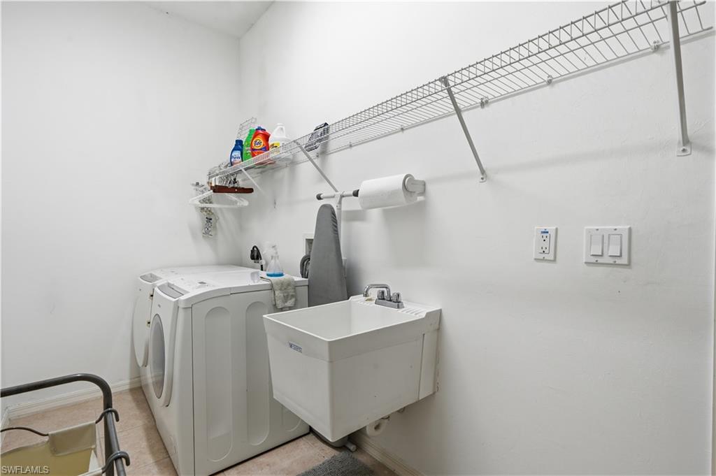 Dedicated utility room featuring a built-in wire shelving system, a wall-mounted utility sink with a chrome faucet, and textured wall finish