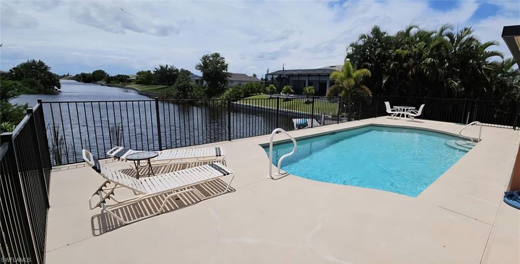 Rectangular swimming pool with integrated steps, surrounded by a light-toned patio deck