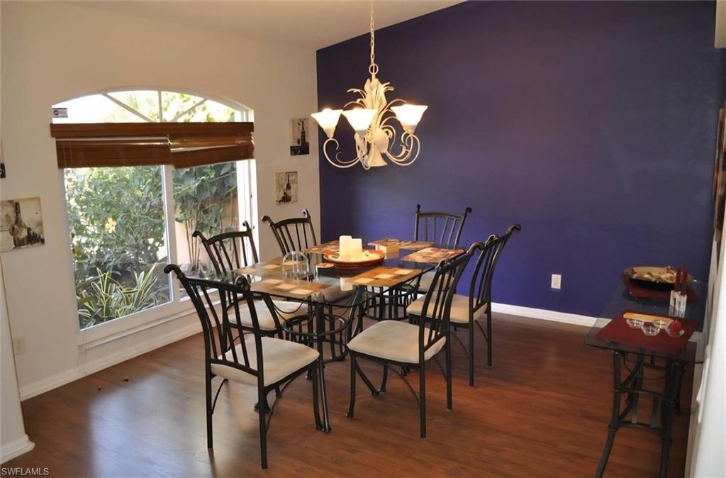 Dining area featuring wood-finish flooring and a distinctive accent wall