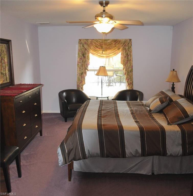 Spacious bedroom featuring light lavender walls and wall-to-wall carpeting
