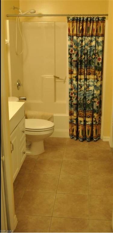 Bathroom featuring a white vanity with cabinet storage, a toilet, and a shower-tub combination