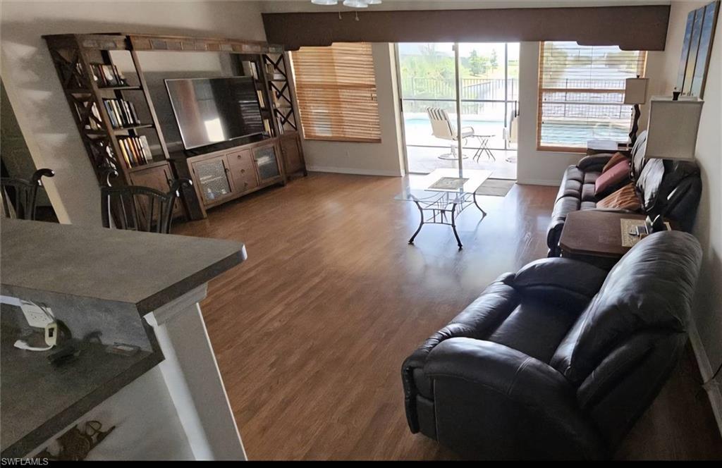 Open-concept living area featuring wood-finish flooring, a built-in media center, and sliding glass doors