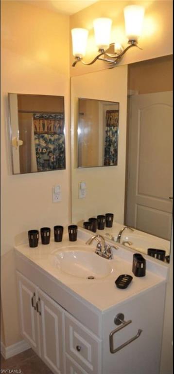 Bathroom vanity with an integrated sink, polished chrome faucet, and white cabinetry