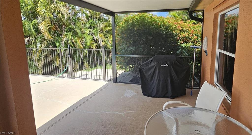 Screened patio featuring a concrete surface, a white-framed window, and a perimeter fence