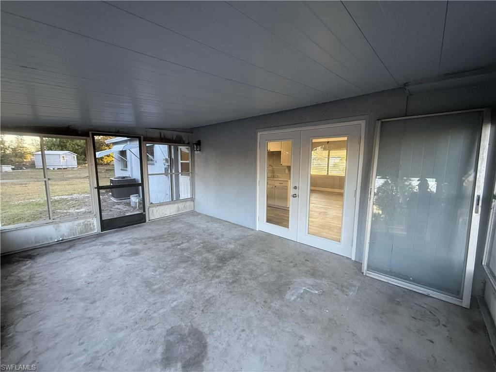 Screened porch with concrete flooring and a paneled ceiling