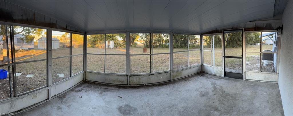 Enclosed patio featuring a screened perimeter, concrete flooring, and a screened door providing exterior access