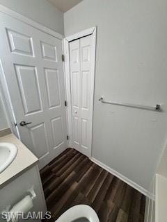 Bathroom with toilet, vanity, and hardwood / wood-style flooring