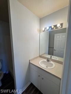 Bathroom with vanity, hardwood / wood-style flooring, and toilet