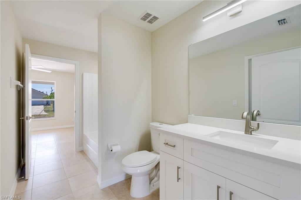Spa-inspired primary bathroom featuring a floating vanity with dual sinks, quartz countertop, and brushed nickel fixtures