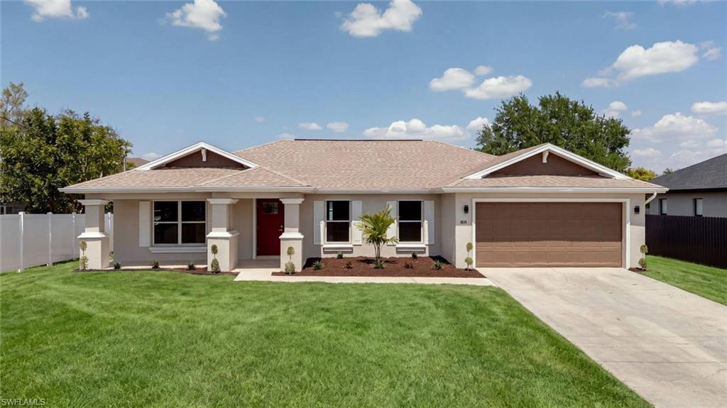 Contemporary single-story residence featuring a clean-lined facade with dual gabled rooflines, a three-car attached garage with brown finish door, and a manicured front lawn bordered by mature landscaping