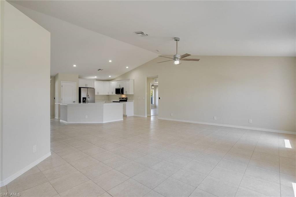 Spacious open-concept living area with tile flooring throughout, recessed lighting, and ceiling fan