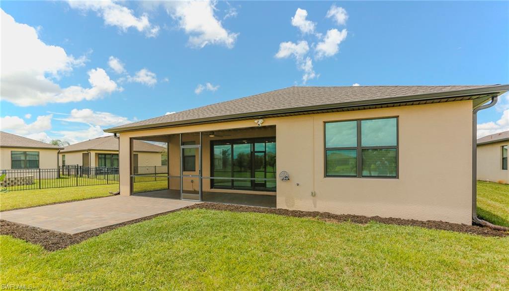 Expansive backyard with a screened porch, concrete patio, and manicured lawn