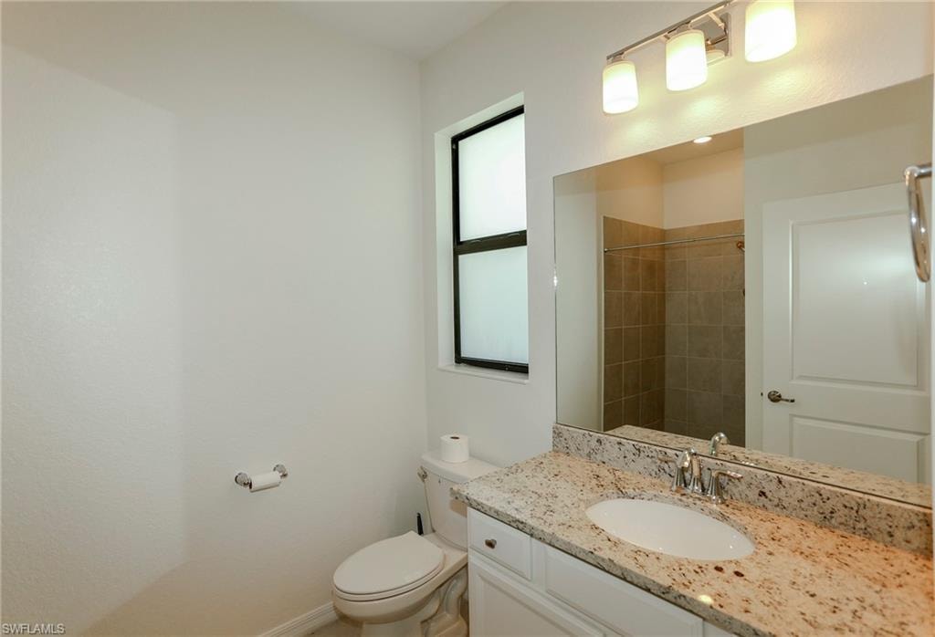 Bathroom featuring a white vanity with a granite countertop, undermount sink, and a large mirror