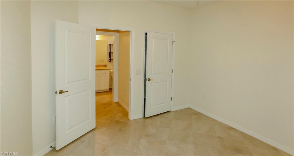 Neutral tone wall paint, paneled interior doors, and tile flooring
