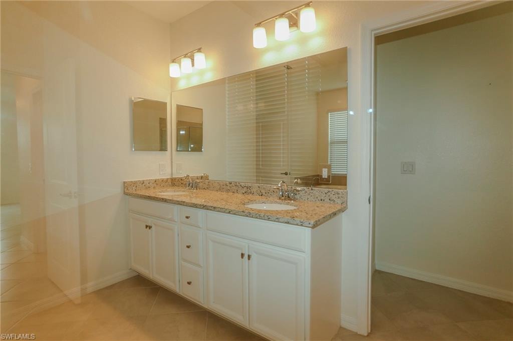 Dual vanity with granite-style countertop, undermount sinks, and white cabinetry