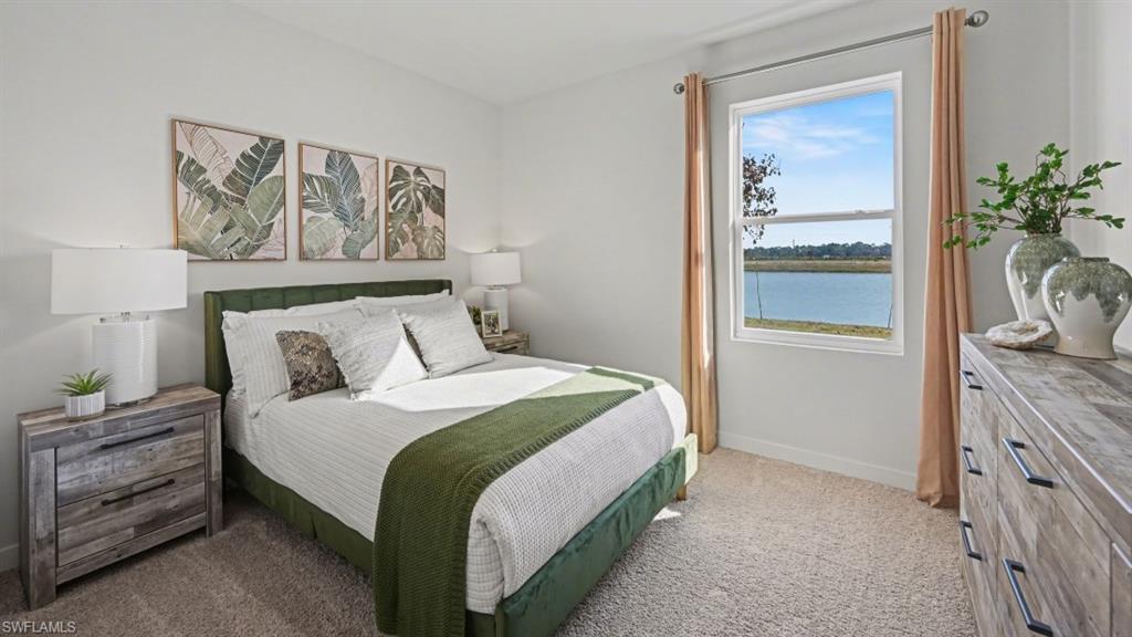 Bright interior room featuring a large window with a scenic water backdrop, neutral wall tones, and plush carpeting