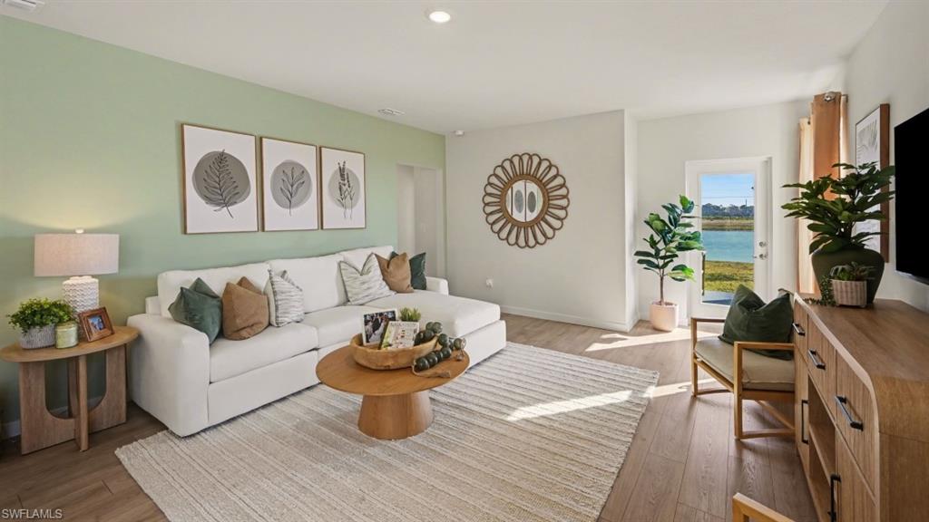 Spacious living area featuring light wood-finish flooring, recessed lighting, and direct outdoor access