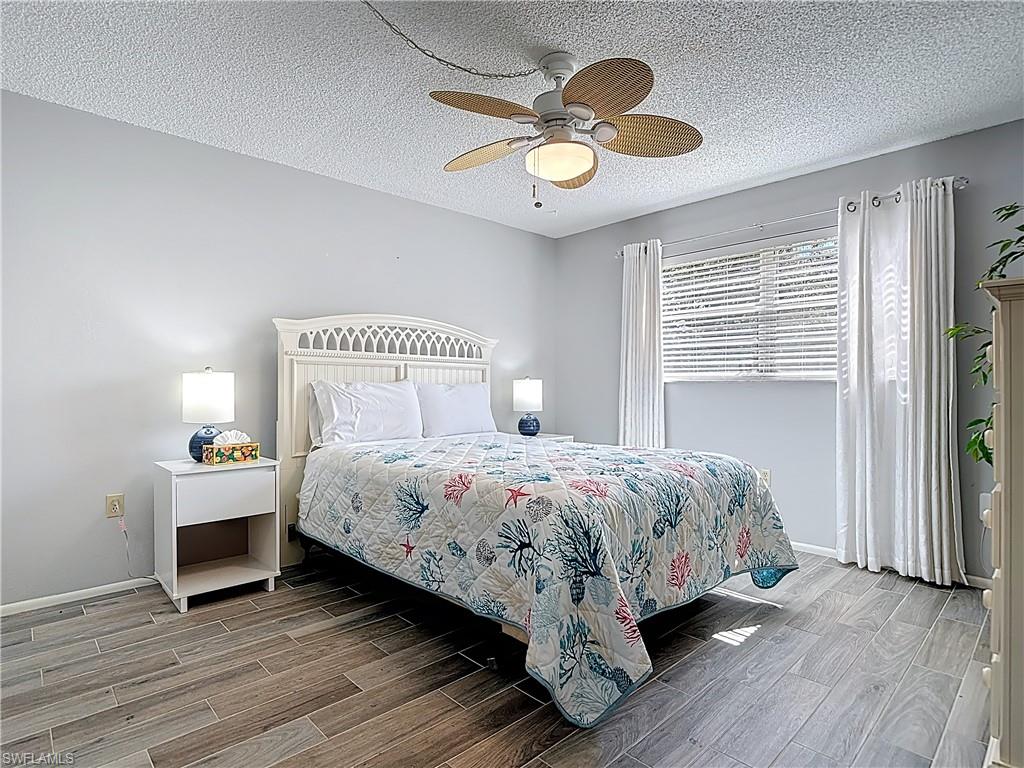 Bedroom featuring wood tiled floors, a textured ceiling, and ceiling fan