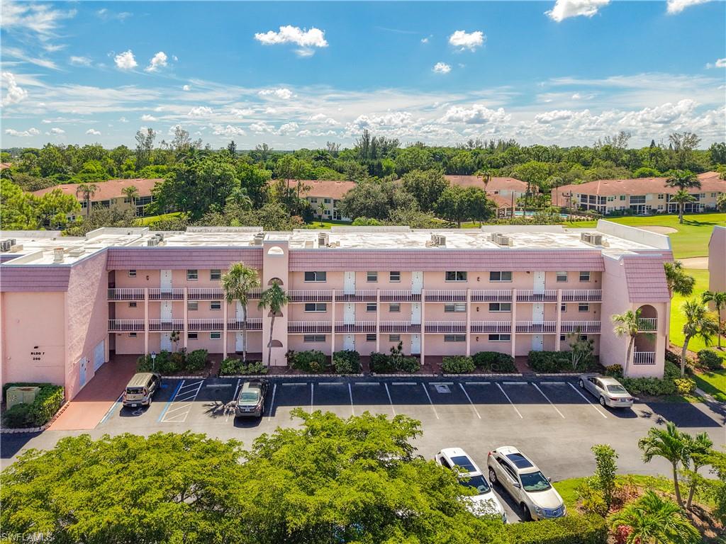 View of apartment building / complex with uncovered parking