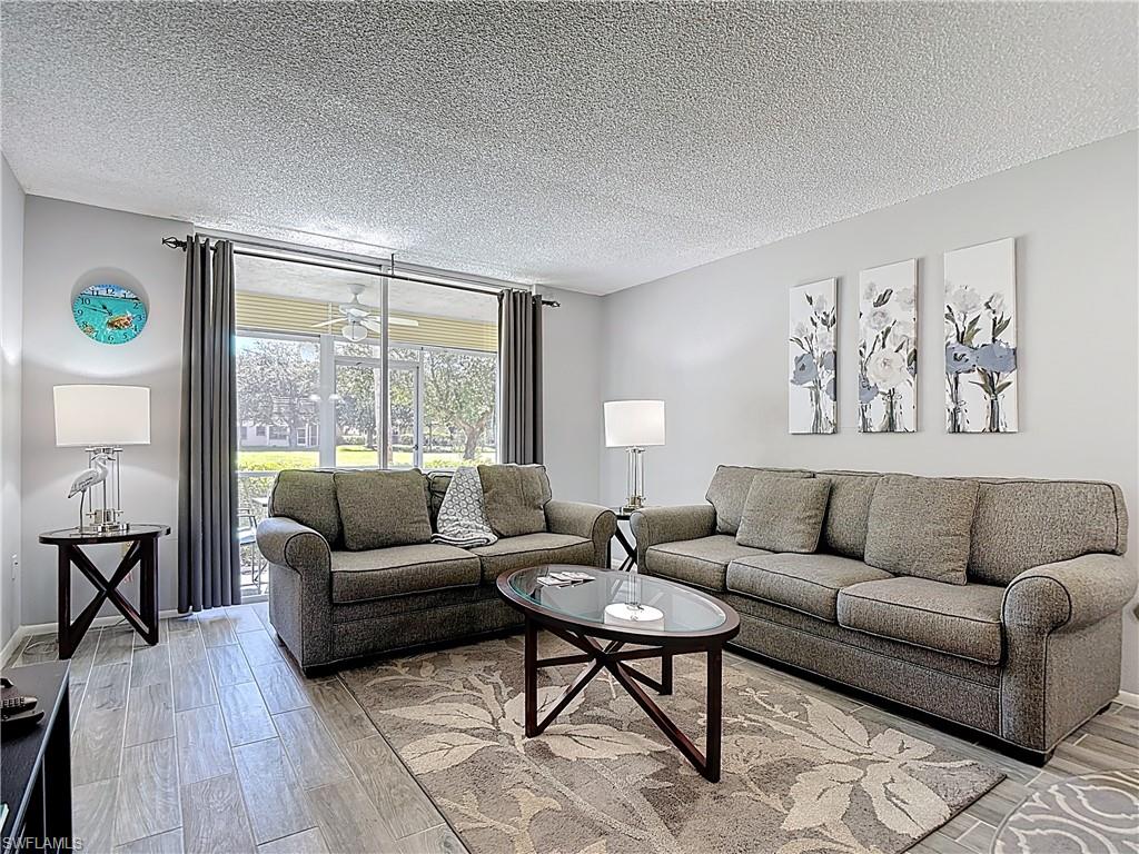 Living room featuring light wood finished floors and a textured ceiling