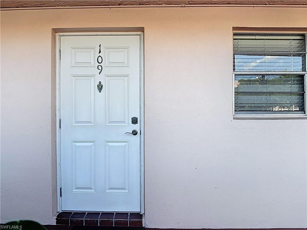 Property entrance featuring stucco siding