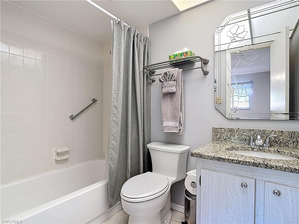 Bathroom featuring vanity and shower / bath combination with curtain
