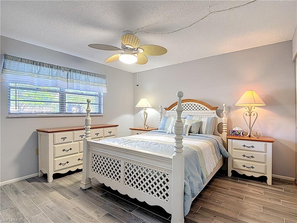 Bedroom featuring wood tiled floors, a textured ceiling, and ceiling fan