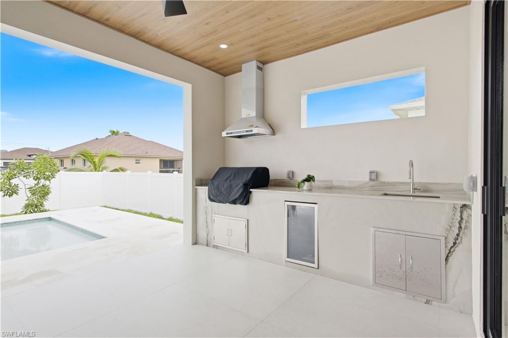 Built-in outdoor kitchen complete w/ grill, hood, sink, beverage refrigerator & storage
