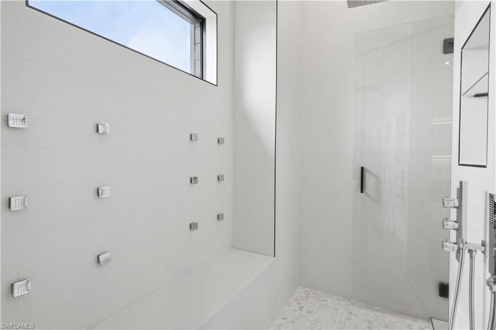 Oversized dual walk-in showers w/ rainfall fixtures, handheld sprayers, body sprays & designer finishes throughout